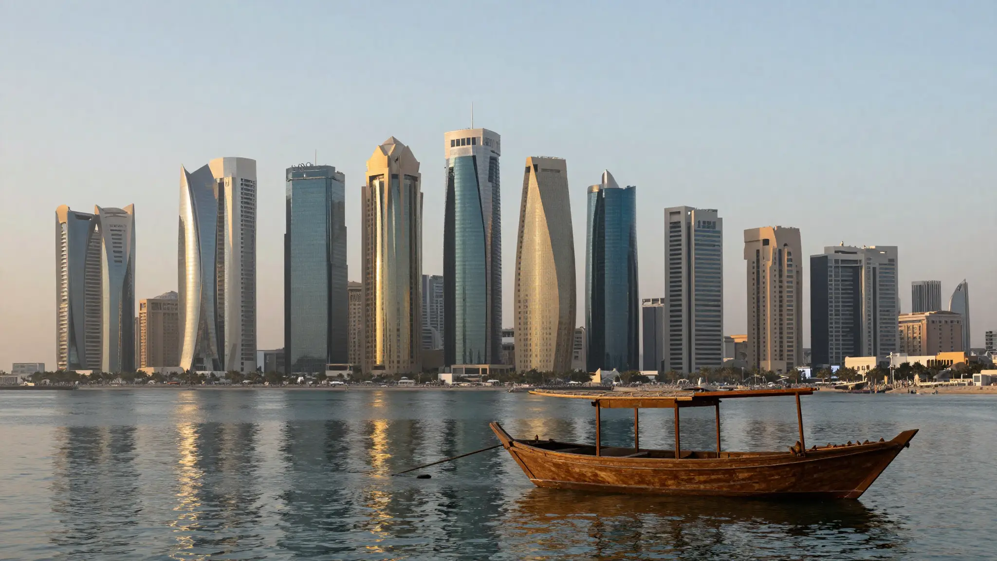 أفق مدينة الدوحة عاصمة قطر مع ناطحات السحاب على الكورنيش وقارب تقليدي في الخليج العربي عند الغروب